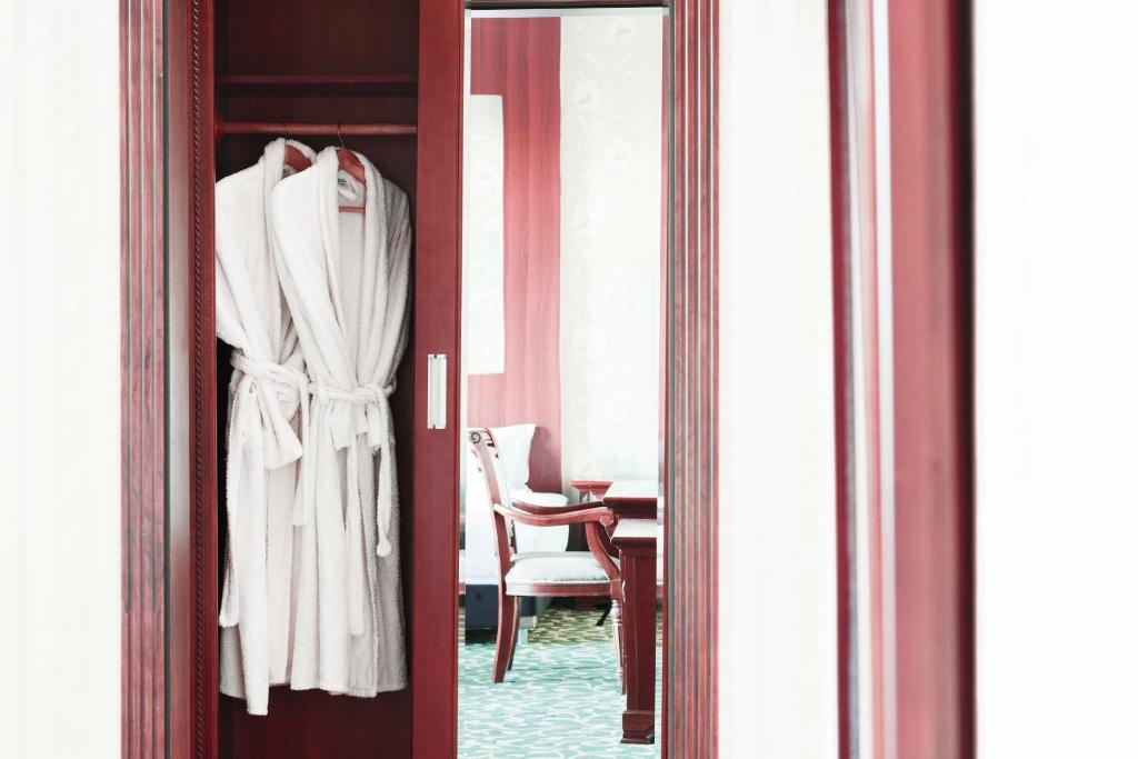 - une porte avec un peignoir et une chaise dans la chambre dans l'établissement Western Suites Hotel, à Tachkent