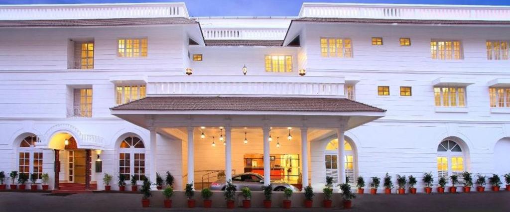 um grande edifício branco com um alpendre em frente em Hotel Luciya Palace em Thrissur