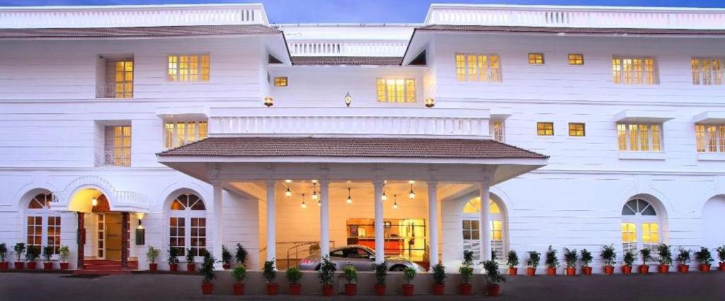 a large white building with a porch in front of it at Hotel Luciya Palace in Trichūr