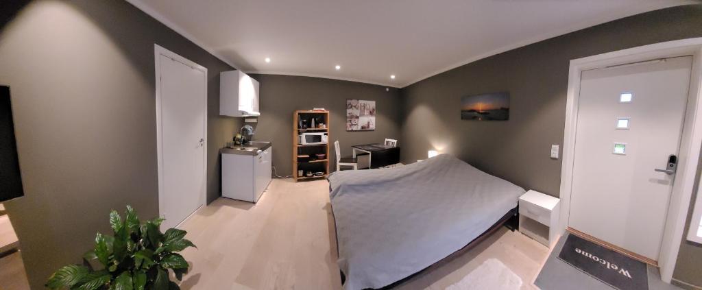 une chambre avec un lit et un réfrigérateur. dans l'établissement Stilren suite med egen inngang og kokemuligheter., à Tromsø