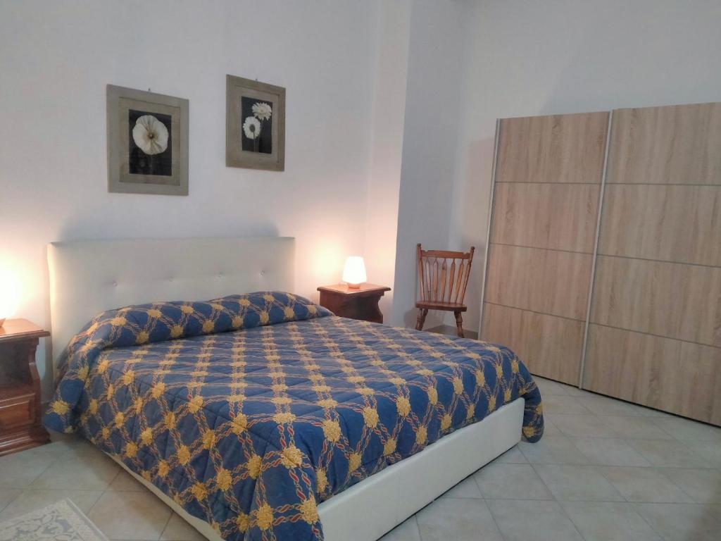 - une chambre dotée d'un lit avec une couverture bleue et jaune dans l'établissement Holiday Villa, à Osilo