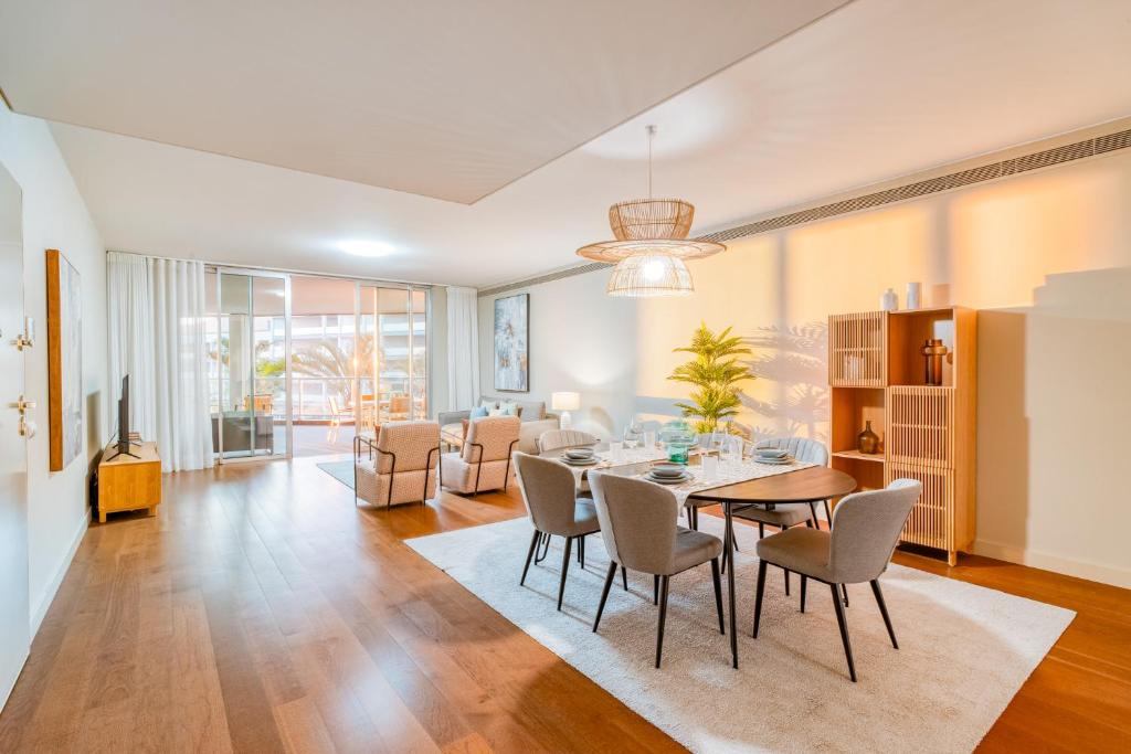 una sala da pranzo e un soggiorno con tavolo e sedie di Suite BM - 3 Pools-Gym-AC-Huge Balcony Sea View a Funchal