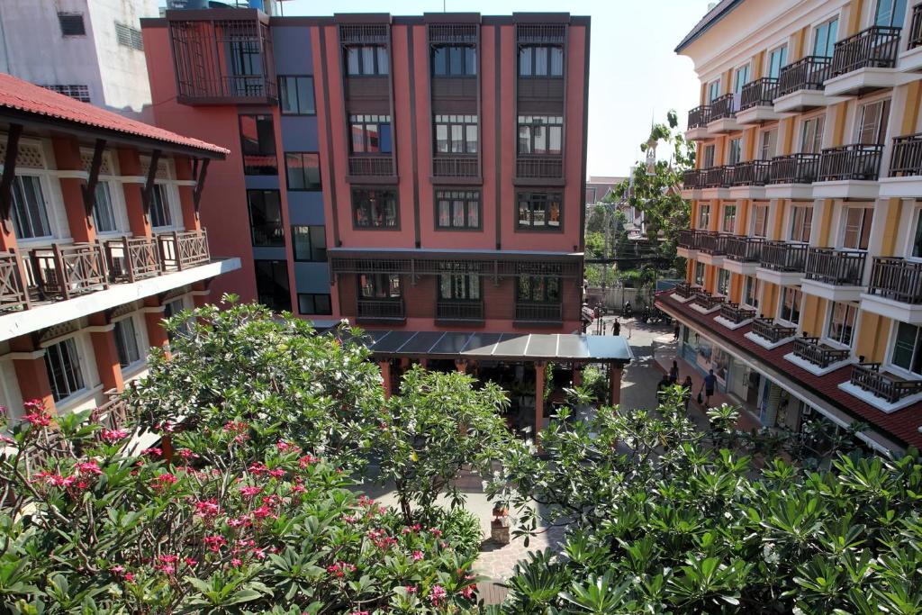 Rambuttri Village Plaza - SHA Extra Plus في بانكوك: اطلالة علوية على مبنى به اشجار وورود