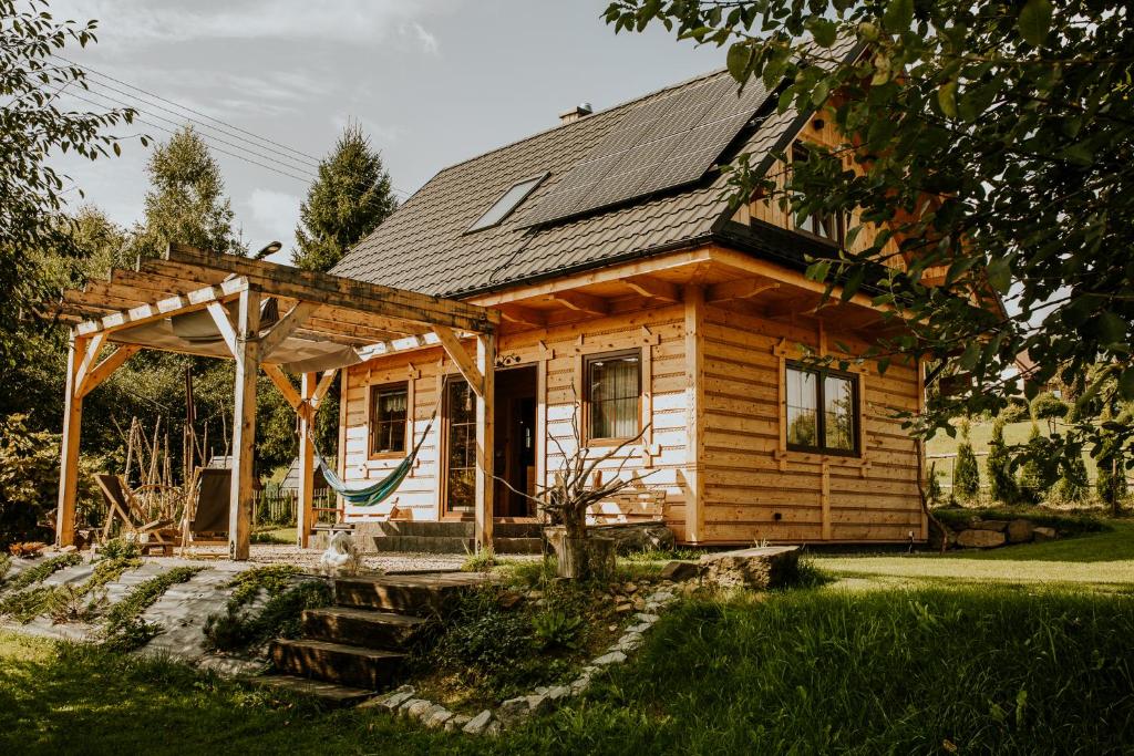 a small wooden house with a gazebo at Prawie na końcu drogi in Skomielna Biała