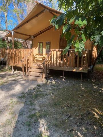 een klein huis met een veranda en een veranda bij Lodges & Nature - 47 in Avignon