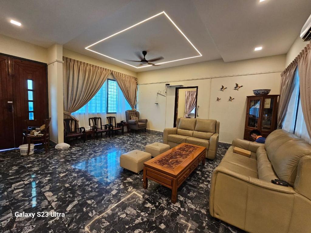 uma grande sala de estar com sofás e uma mesa em Lasam Heritage Villa + Glamping in the House 24pax with Karaoke & Snooker em Ipoh