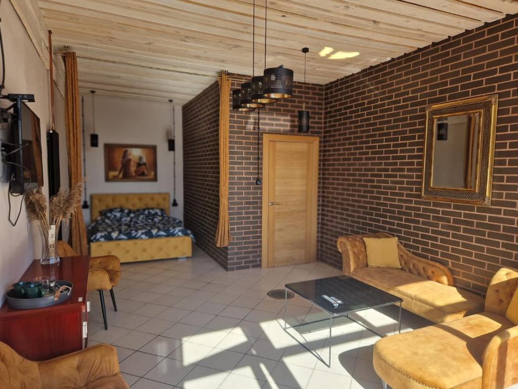 a living room with a bed and a brick wall at WILLA VASCO KAPITAN in Rewa