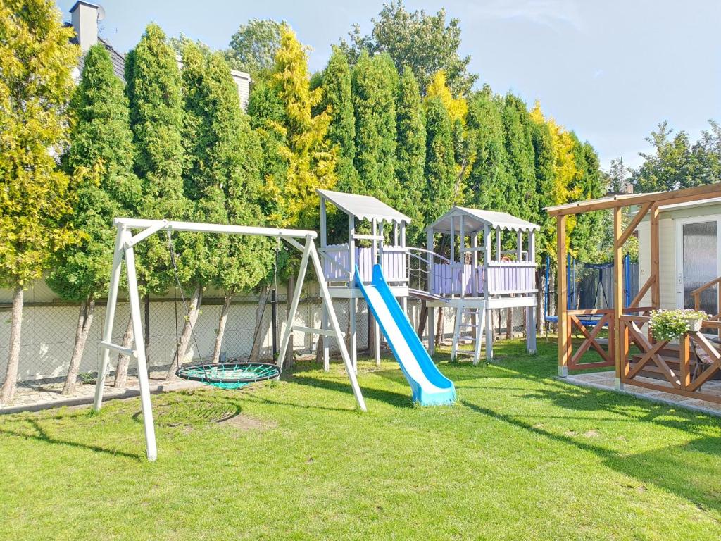 un patio con parque infantil con tobogán en Azur Domki blisko plaży, en Mielno