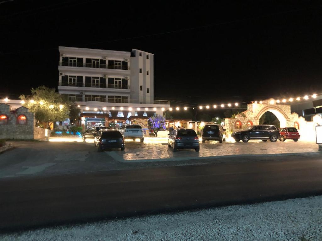 um parque de estacionamento com carros estacionados em frente a um edifício em Floger world em Vlorë