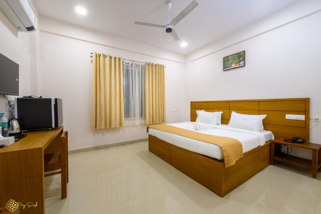 1 dormitorio con 1 cama y TV en Daffodils Luxury Airport Suites en Angamali