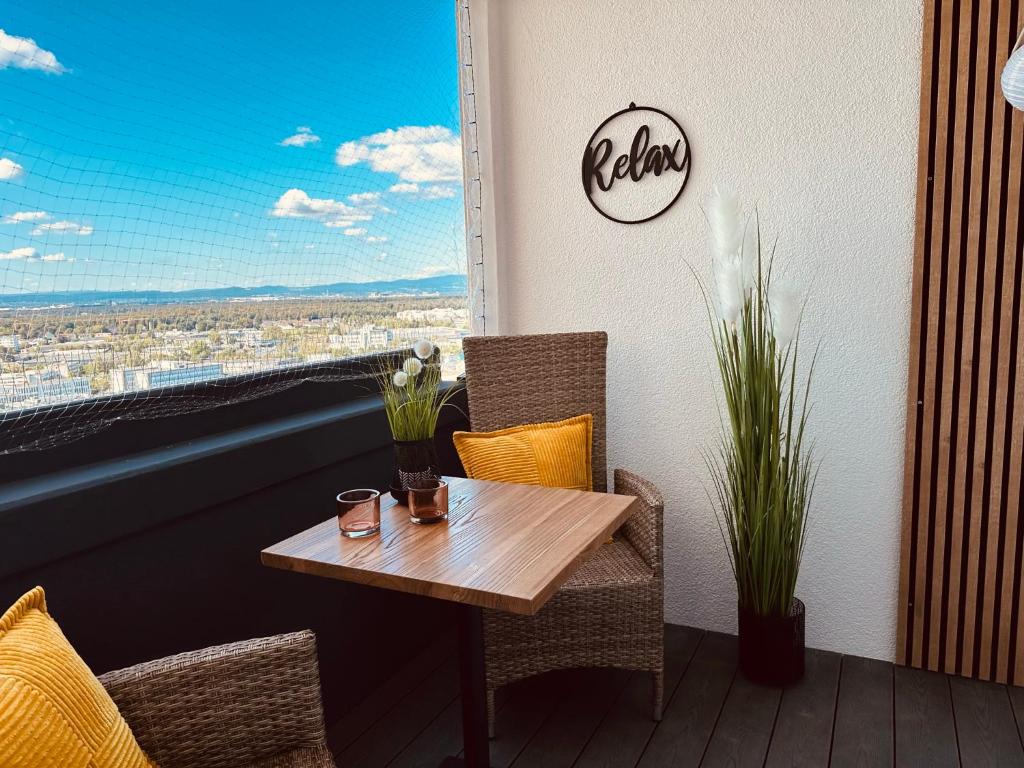 una mesa y sillas en un balcón con vistas en FeWo SKY21 * Langen EXKLUSIVES APPARTMENT Vollausstattung / zentrale Lage *NEU*, en Langen