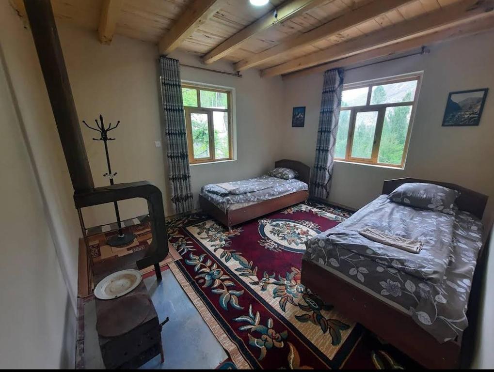 a room with two beds and a rug at Jumaboy Guesthouse 