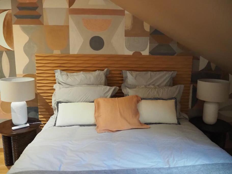 a bed with two pillows on it with two lamps at Maison en centre ville avec extérieur in Compiègne