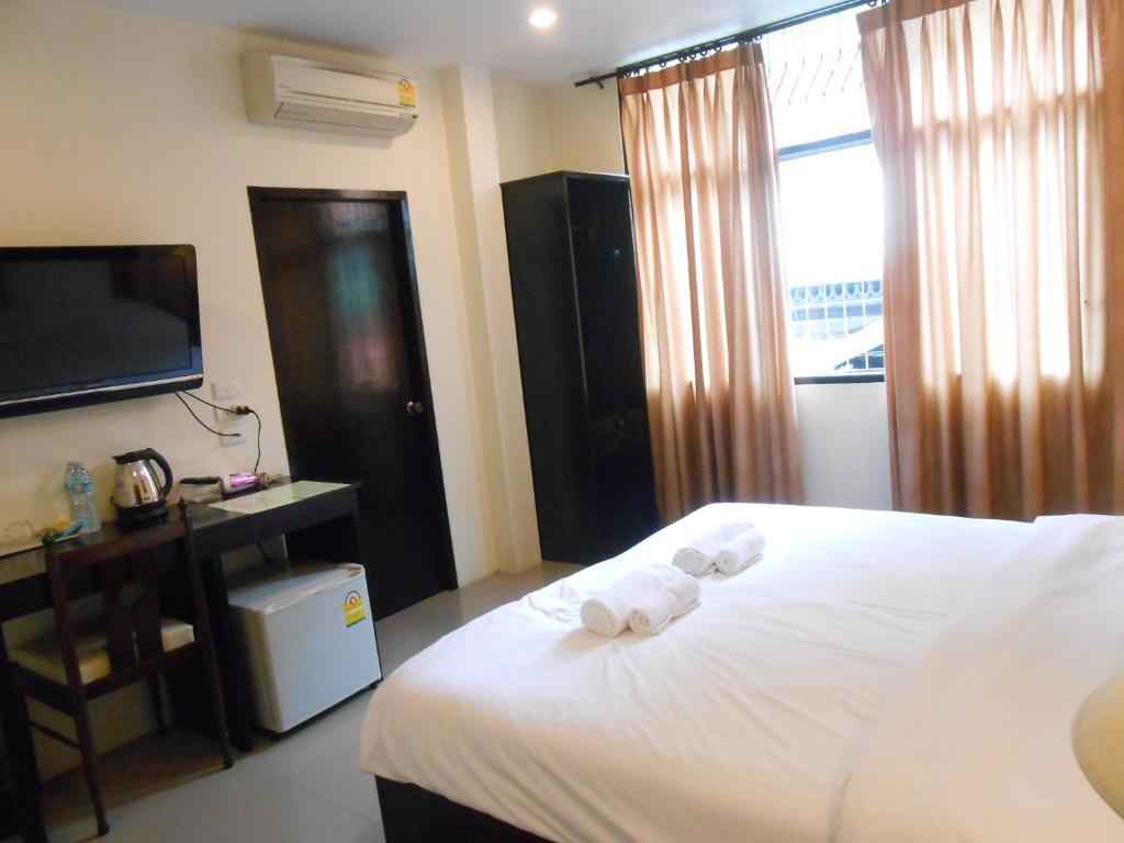 The Bang Khun Phrom Suites tesisinde bir odada yatak veya yataklar