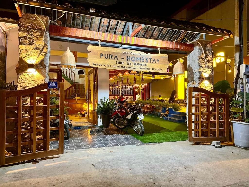 een winkel met een motor geparkeerd voor de deur bij Pura Homestay in Na Thôn