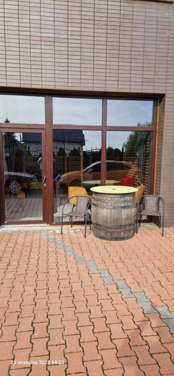 a patio with a table and chairs and a table and windows at WILLA VASCO BOSMAN in Rewa