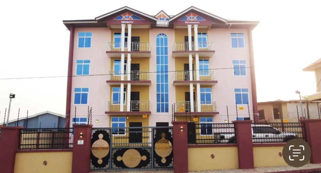 a building with blue windows and a fence at CNC Rehoboth Villa in Accra