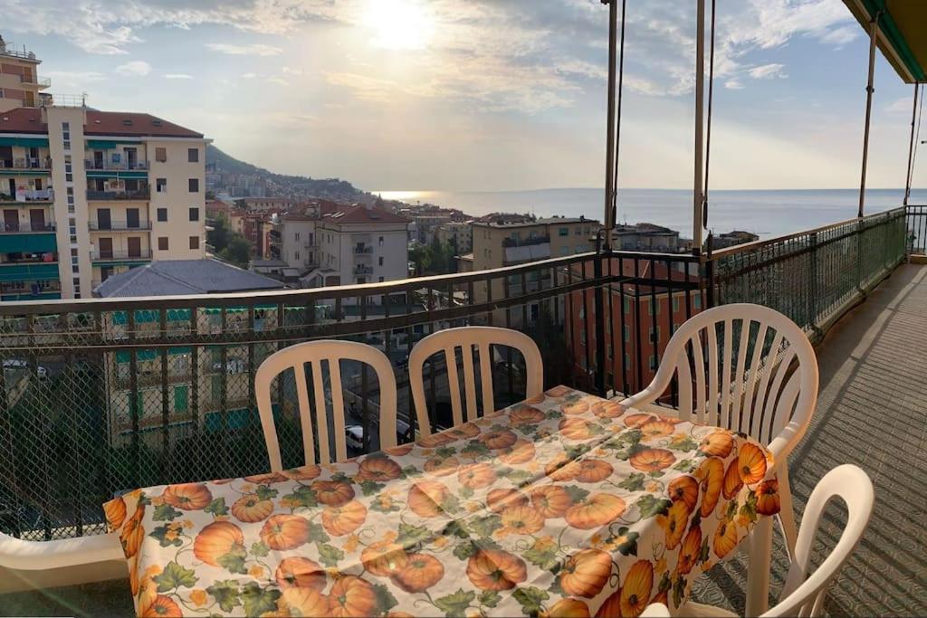 a table and chairs on a balcony with a view of the ocean at Vista mare con ogni comfort in Varazze