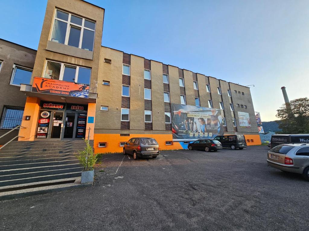 un edificio con coches estacionados en un estacionamiento en Ubytování Střekov Aréna, en Ústí nad Labem