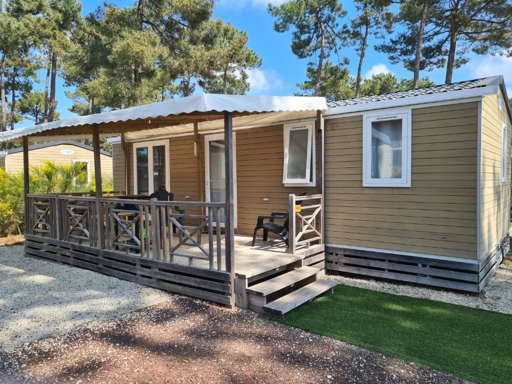 una casa pequeña con porche y terraza en Mobil Home Comfort XL 6 Personnes Montalivet, en Vendays-Montalivet