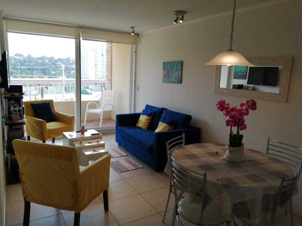 a living room with a blue couch and a table at Acogedor Departamento en tranquilo balneario, Papudo in Papudo