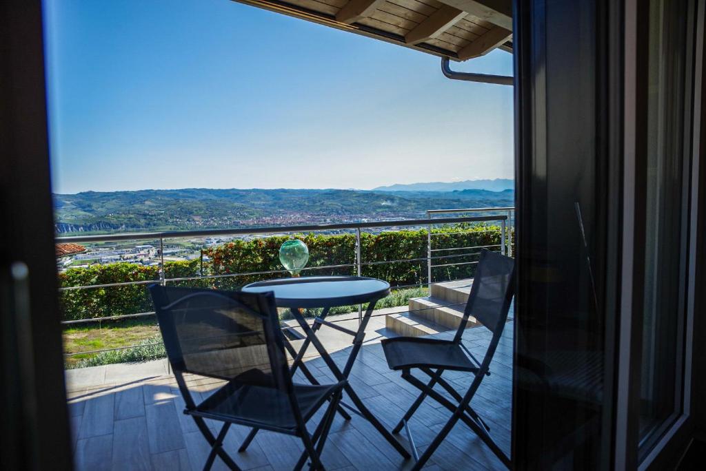 uma mesa e cadeiras numa varanda com vista em Vista Langhe - CerratoHouses em Guarene