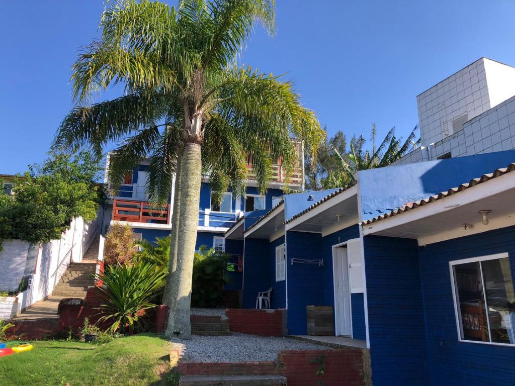 Hospedaria Mirante da Maré ap8 في إيمبيتوبا: نخلة أمام البيت الأزرق