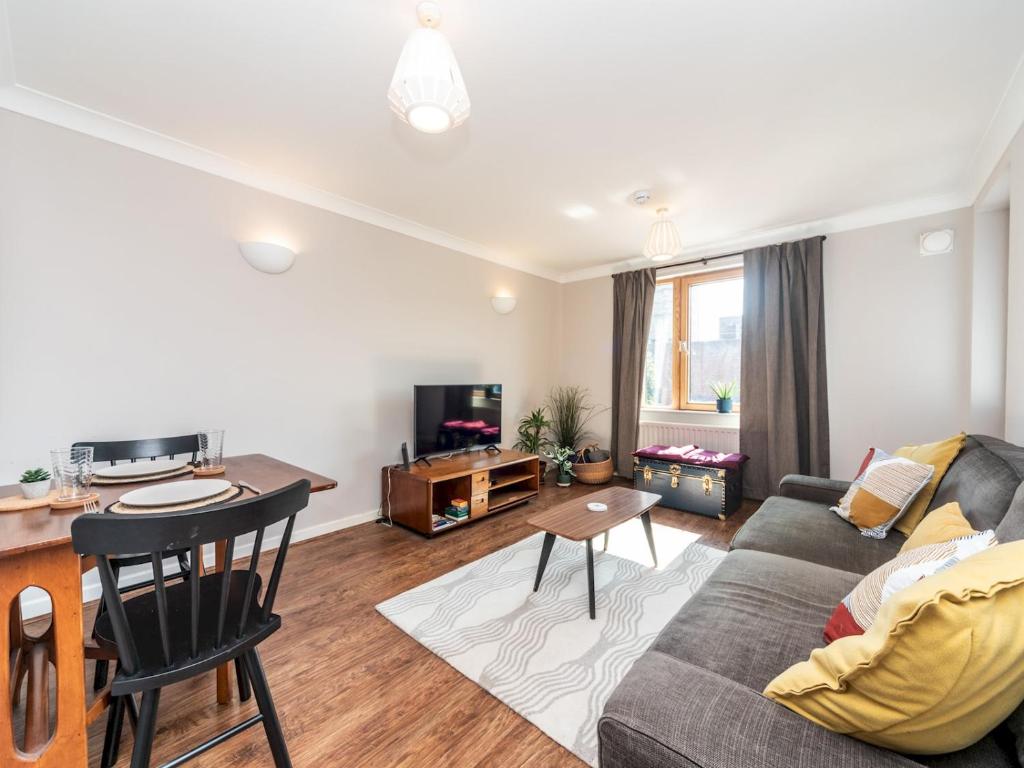 a living room with a couch and a table at Pass the Keys Sidney Street Lovely one bed flat - great base to explore London in London