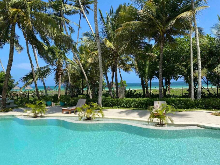 烏昆達的住宿－Dolphin House, Galu Beach, Kenya，棕榈树和海滩的游泳池