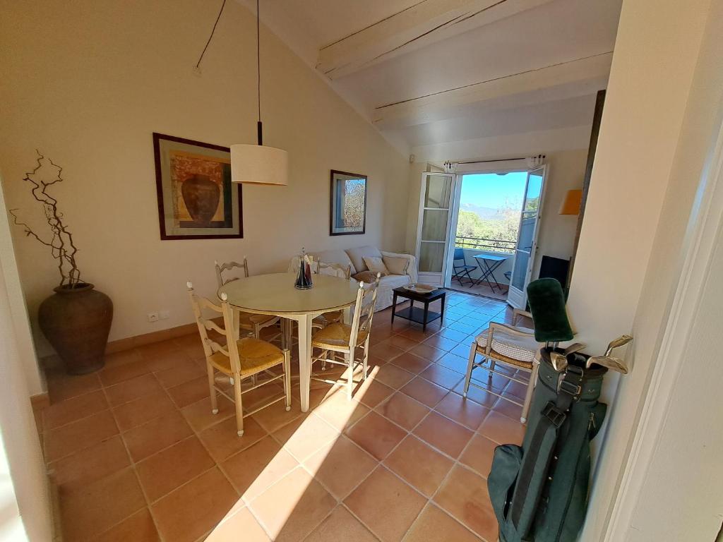 een eetkamer en een woonkamer met een tafel en stoelen bij Appartement F2 dans le golf de Saint-Endréol in La Motte