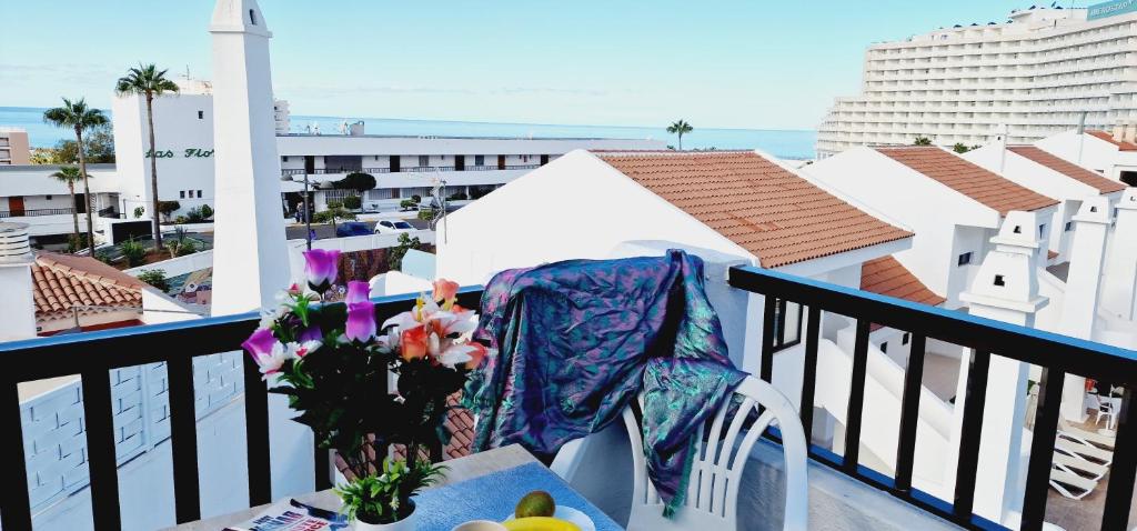 a chair on a balcony with a view of the ocean at Garajonay 3 bedrooms apartment, ocean & pool view in Playa Fañabe