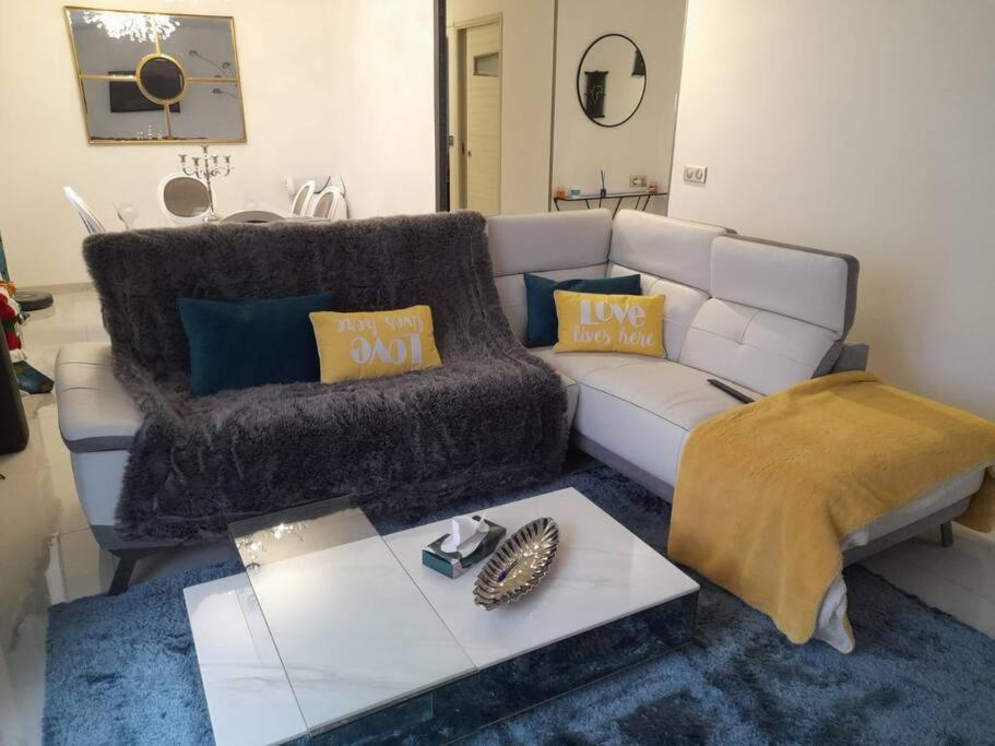 un salon avec un canapé et une table basse dans l'établissement Maison calme proche centre ville, à Coulaines