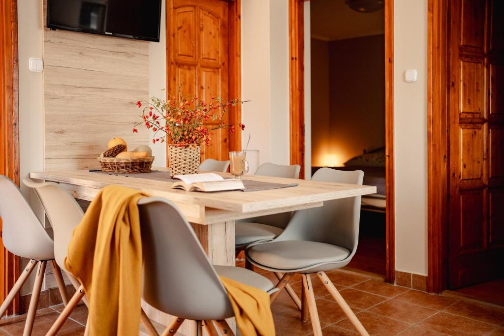 博加奇的住宿－Kotyogó Apartmanok, Bogács，一间带木桌和椅子的用餐室