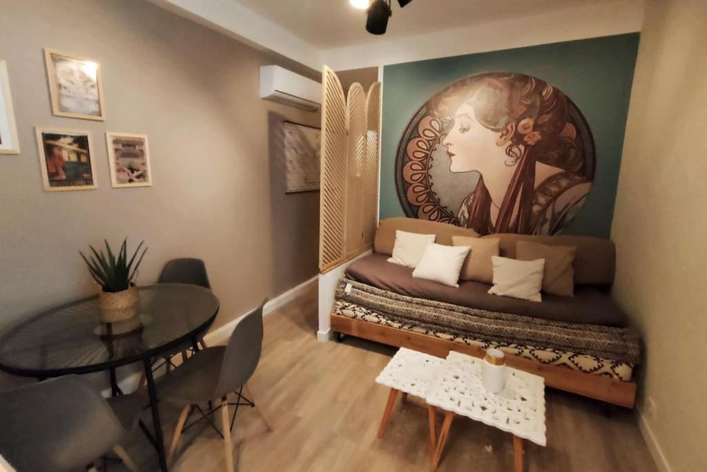 Zimmer mit einem Bett und einem großen Gemälde an der Wand in der Unterkunft «l’Orient Express» joli 2 pièces fonctionnel in Nizza