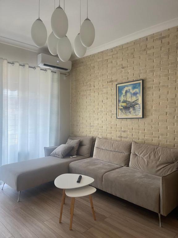un soggiorno con divano e tavolo di Sunny Apartment near Castle a Elbasan