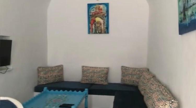 uma sala de estar com um sofá e uma mesa em Dar Blanche em Hammamet