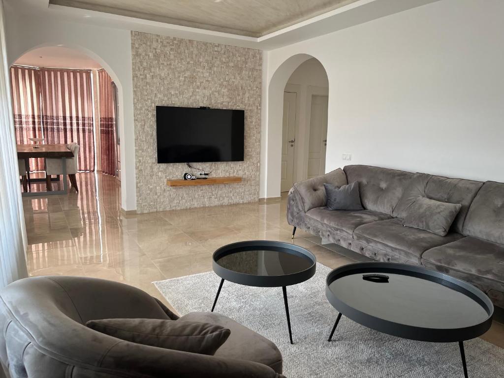 a living room with a couch and a table at Qendresa Apartments in Prishtinë