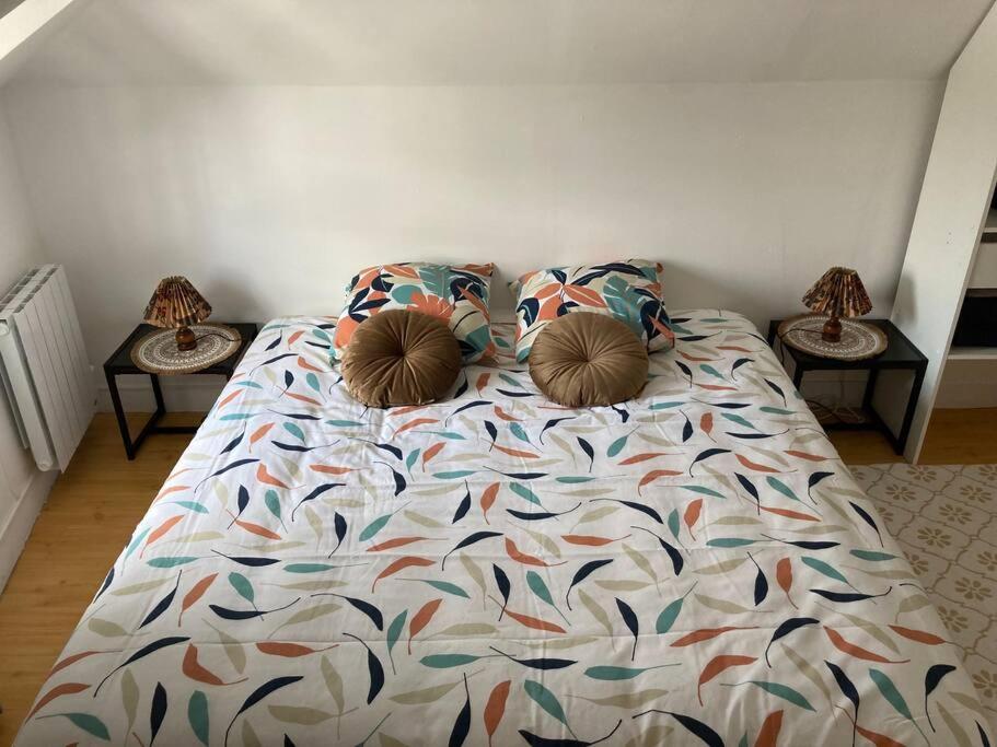 a bed with two pillows on it in a bedroom at Bel appartement hyper centre in Bernay