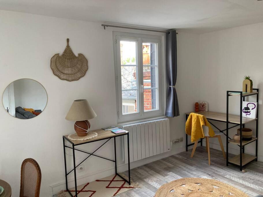 a room with a table and a mirror and a window at Bel appartement hyper centre in Bernay