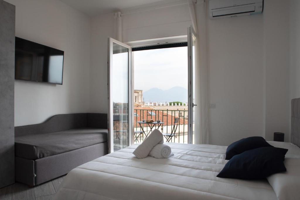 een slaapkamer met een groot wit bed en een balkon bij B&B Monteleone ,12 in Napels