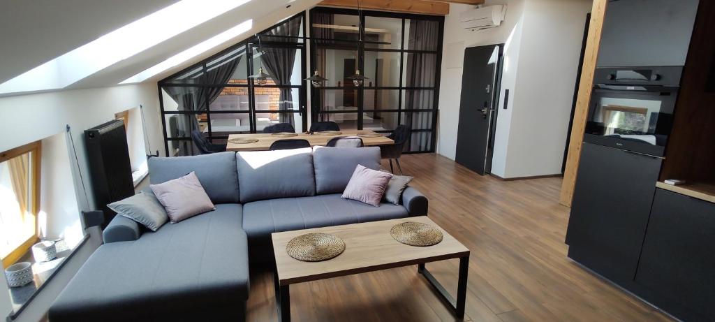 a living room with a blue couch and a table at Apartamenty Comfort in Gniezno