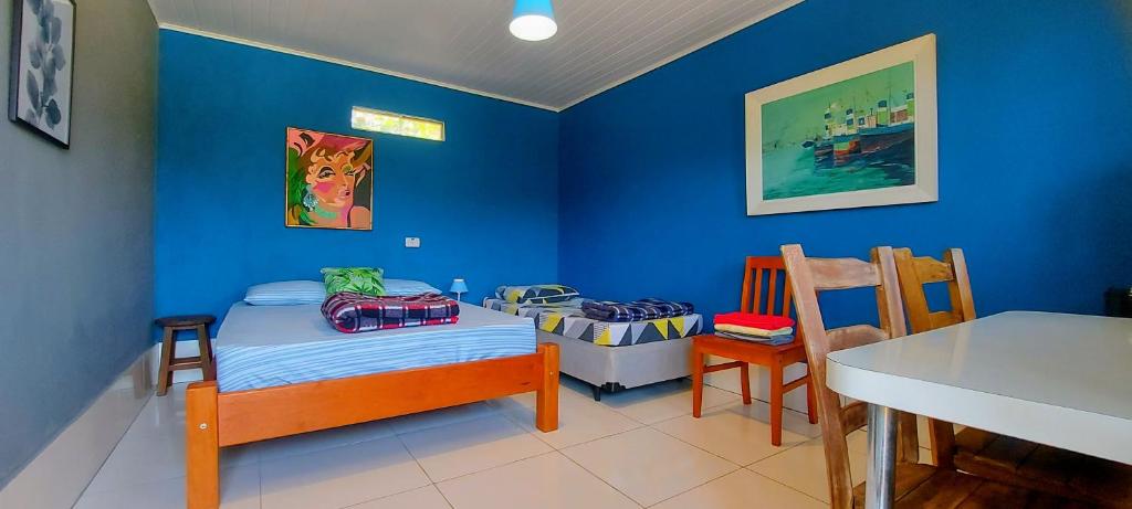 een blauwe kamer met een klein bed en een tafel bij Rancho Acácia São Roque in São Roque