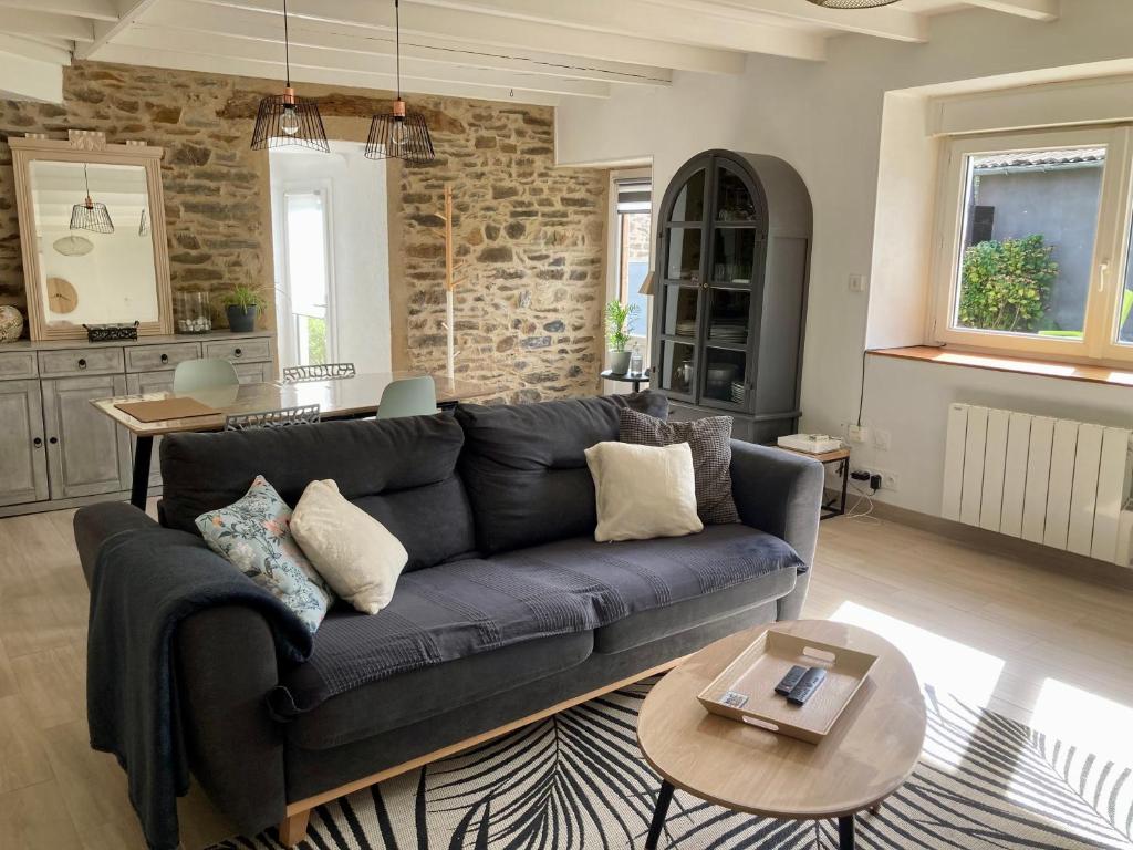 a living room with a blue couch and a table at Authentique maison de pêcheur in Plérin