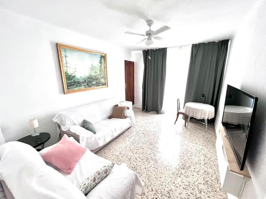 Sala de estar blanca con sofá blanco y mesa en VélezVida Serna, en Vélez Rubio