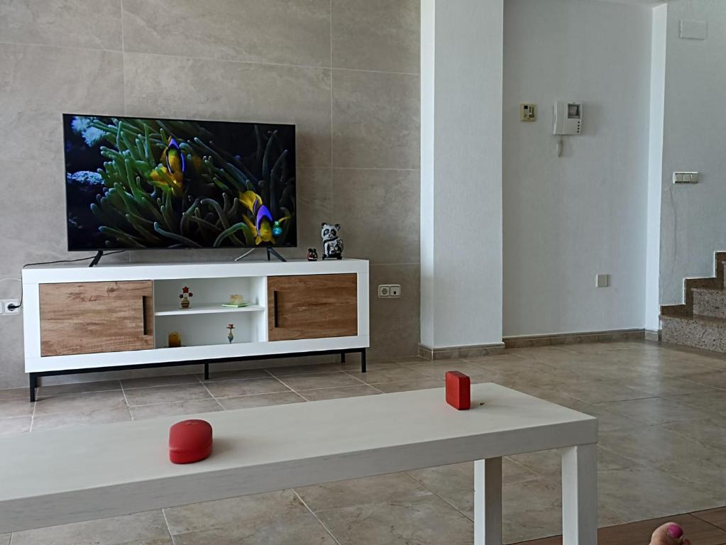 A television and/or entertainment centre at Bungalow en primera línea del mar