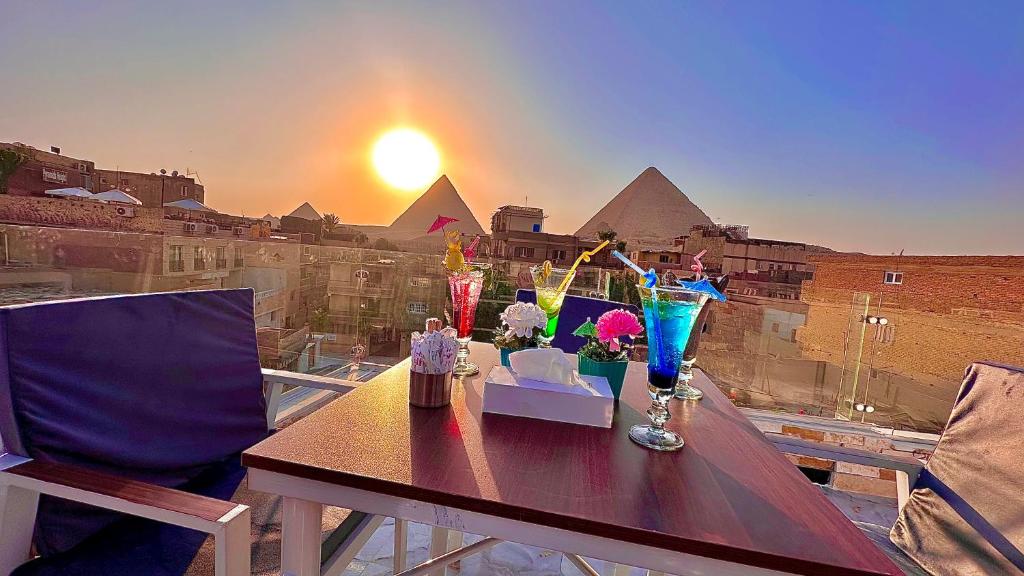 a table on a balcony with a view of the pyramids at Locanda pyramids view in Cairo