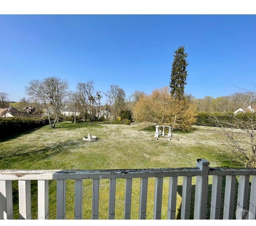 einen großen Hof mit einem weißen Zaun und einem Park in der Unterkunft APPARTEMENT AVEC VUE à 180 DEGRES SUR UN PARC ARBORE CALME PARKING in Senlis