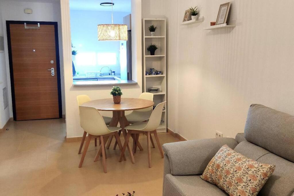 uma sala de estar com uma mesa e cadeiras e um sofá em Condado de Alhama Beautiful New Apartment with Golf Course Views em Alhama de Múrcia