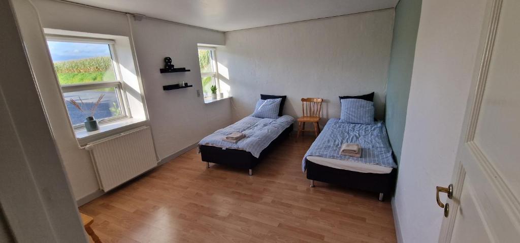 KværndrupにあるILDHU INNのベッド2台と窓が備わる小さな客室です。