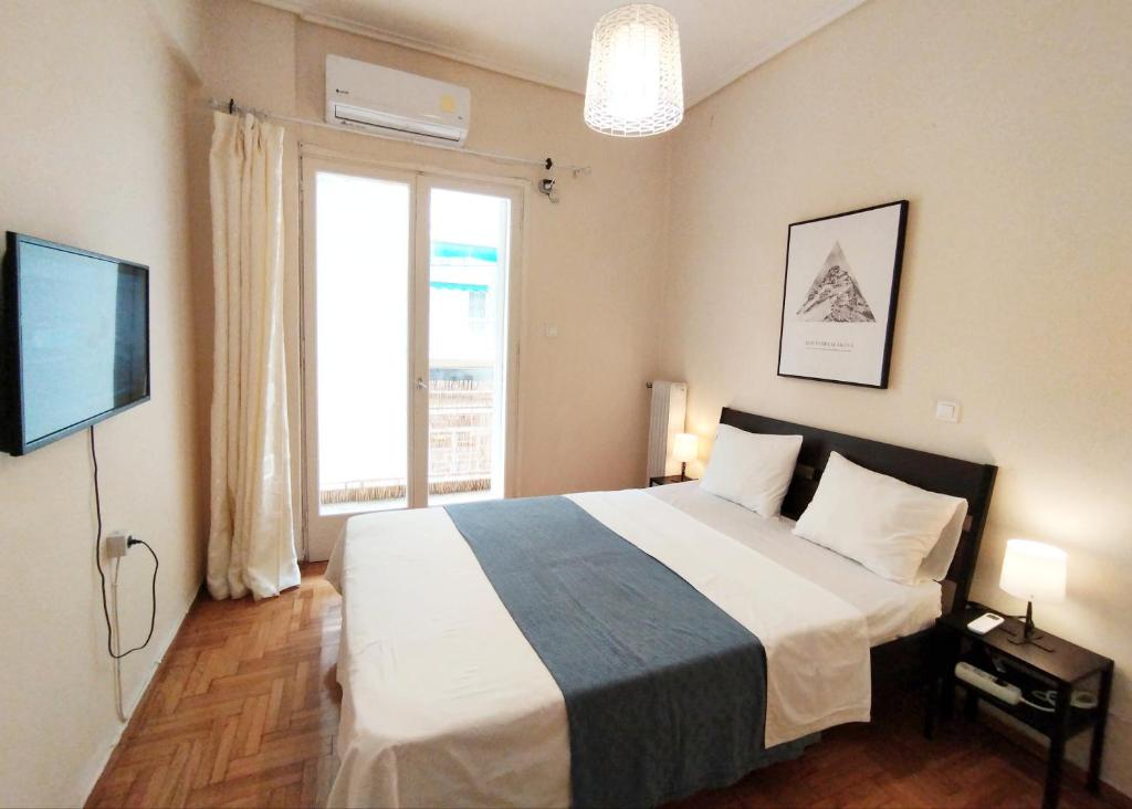 1 dormitorio con 1 cama grande y TV en 生活超便利的小公寓 en Athens
